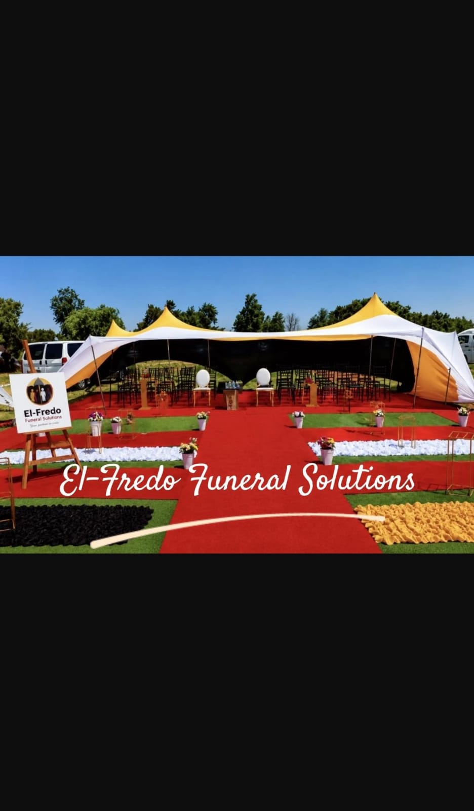 El-Fredo branded tent setup with red carpet, chairs and floral décor